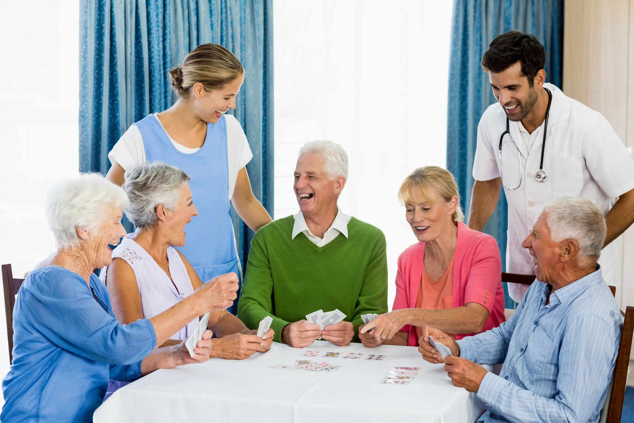Seniors playing cards in a retirement home