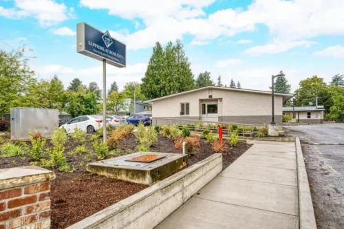 Exterior view of Sapphire at Rose City nursing and rehabilitation center, featuring landscaped gardens and a welcoming entrance.